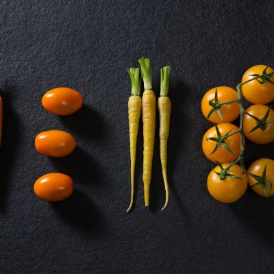 Carrots and tomatoes on black background